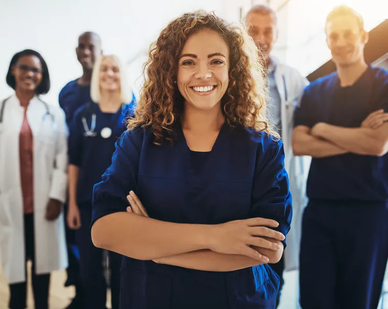 Smiling patient with her care team behind her